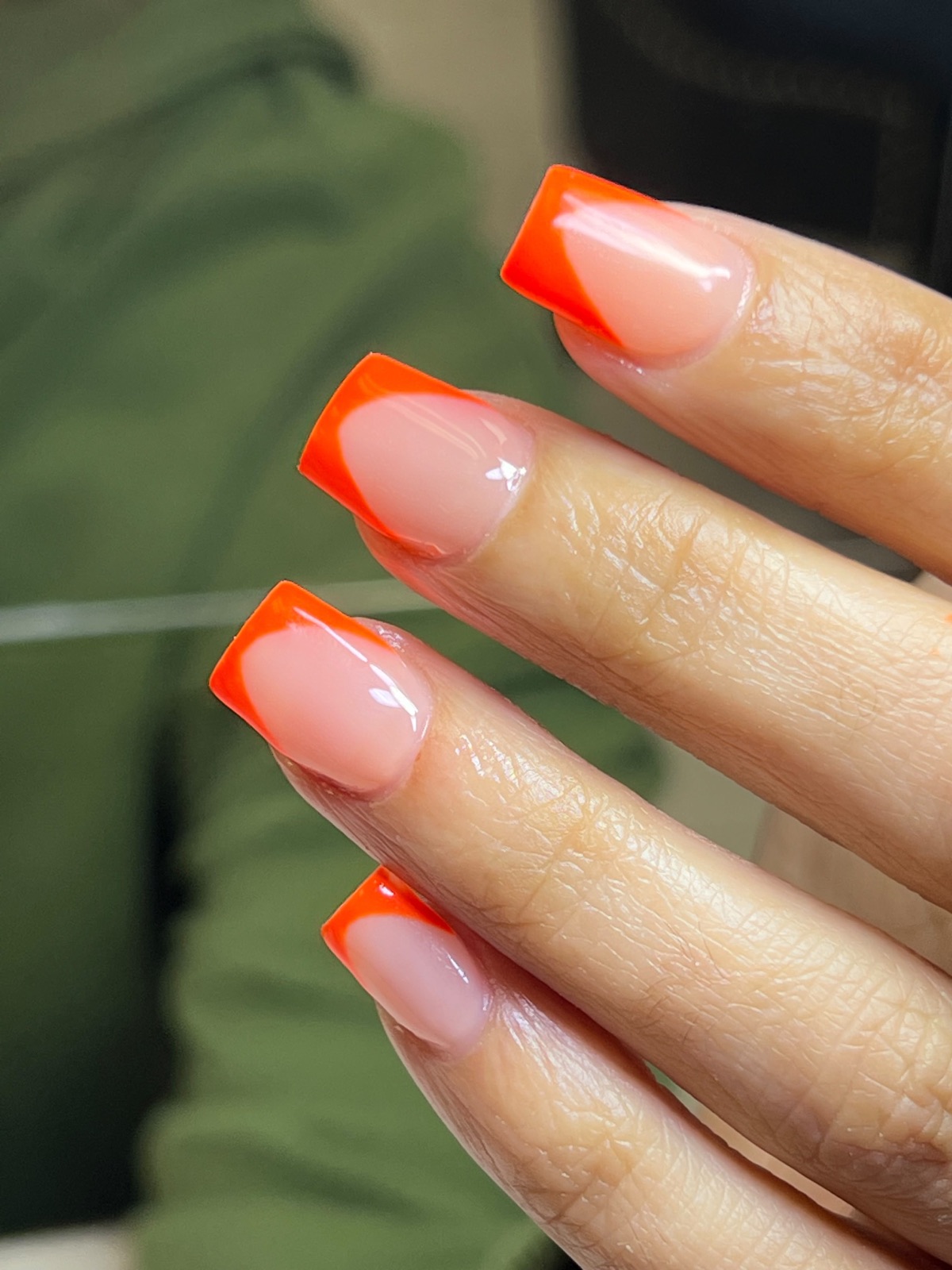 Nude nails with bright orange French tips